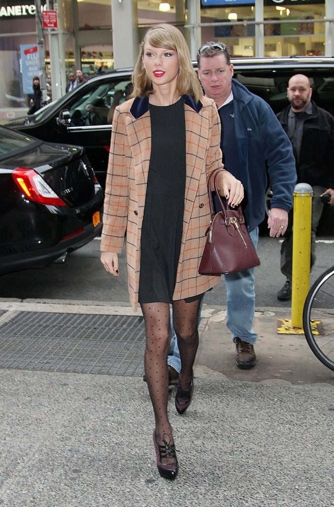Taylor Swift in a tattersall coat over a little black dress